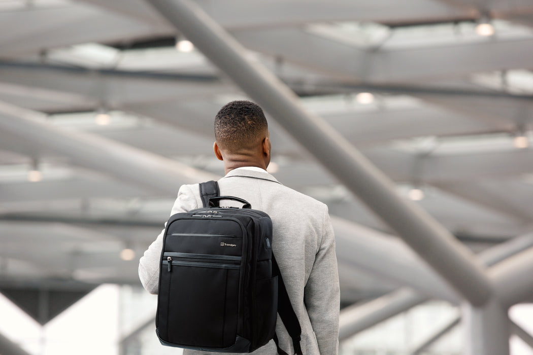 Man holding a Crew Executive Choice 3 Black Backpack walking into airport