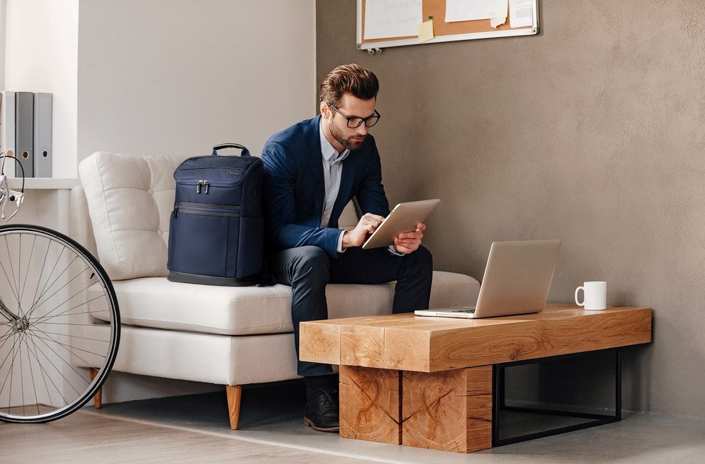 Man sitting at a table with his laptop and backpack