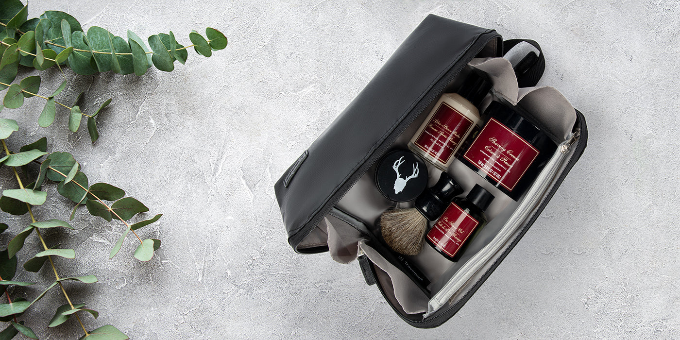 Toiletry Bag laying on marble counter with eucalyptus