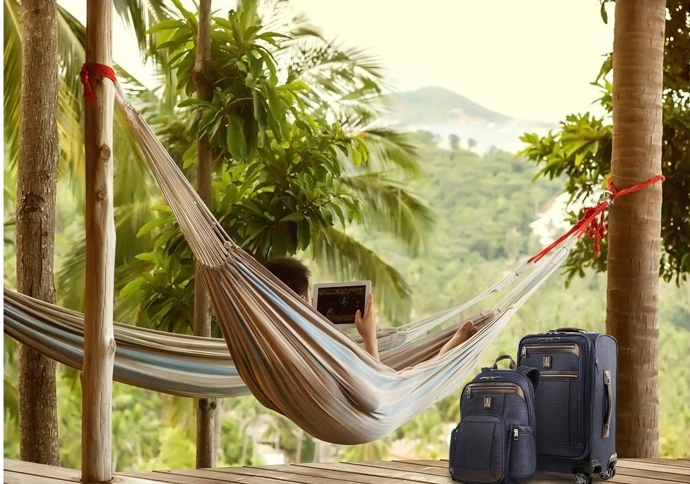 Man in a hammock with luggage next to him