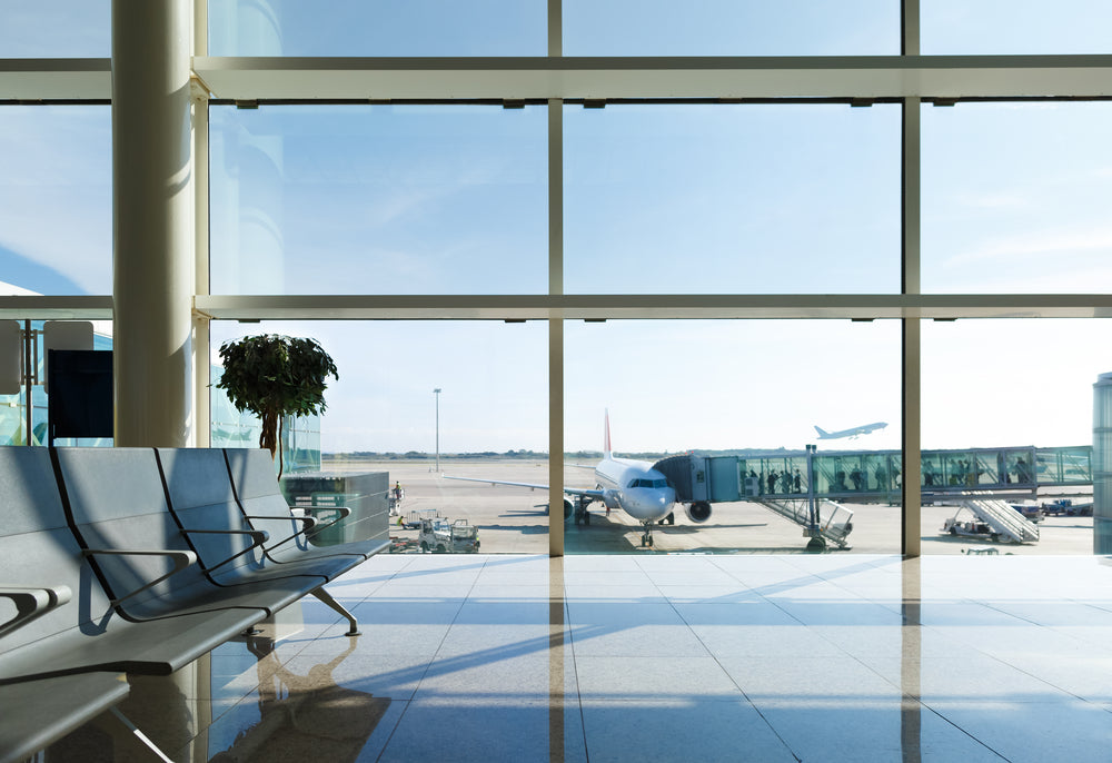 Inside airport lounge area with plane outside window 